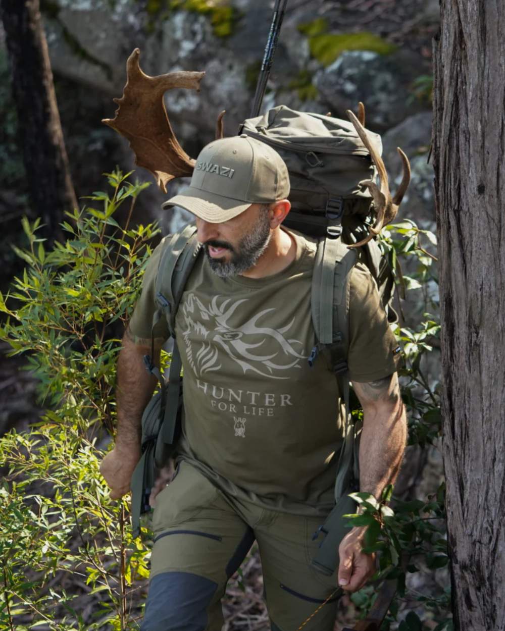 Olive Coloured Swazi Mens Hunter For Life T-Shirt On A Forest Background 