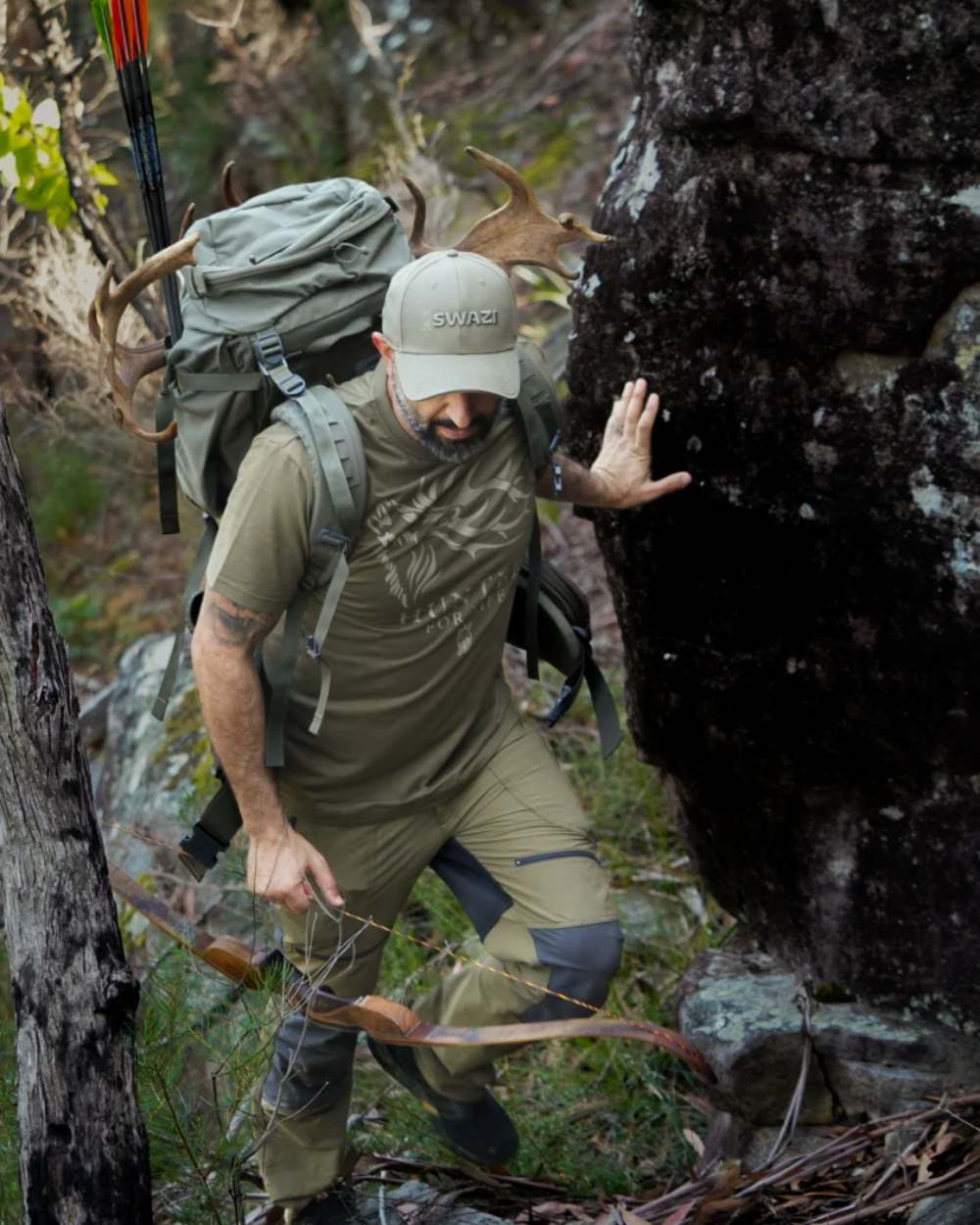 Olive Coloured Swazi Mens Hunter For Life T-Shirt On A Forest Background 