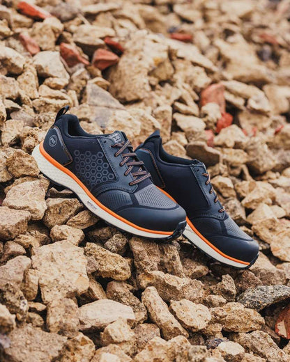 Black/Orange coloured Timberland Pro Reaxion Composite Safety Trainers on stone background 