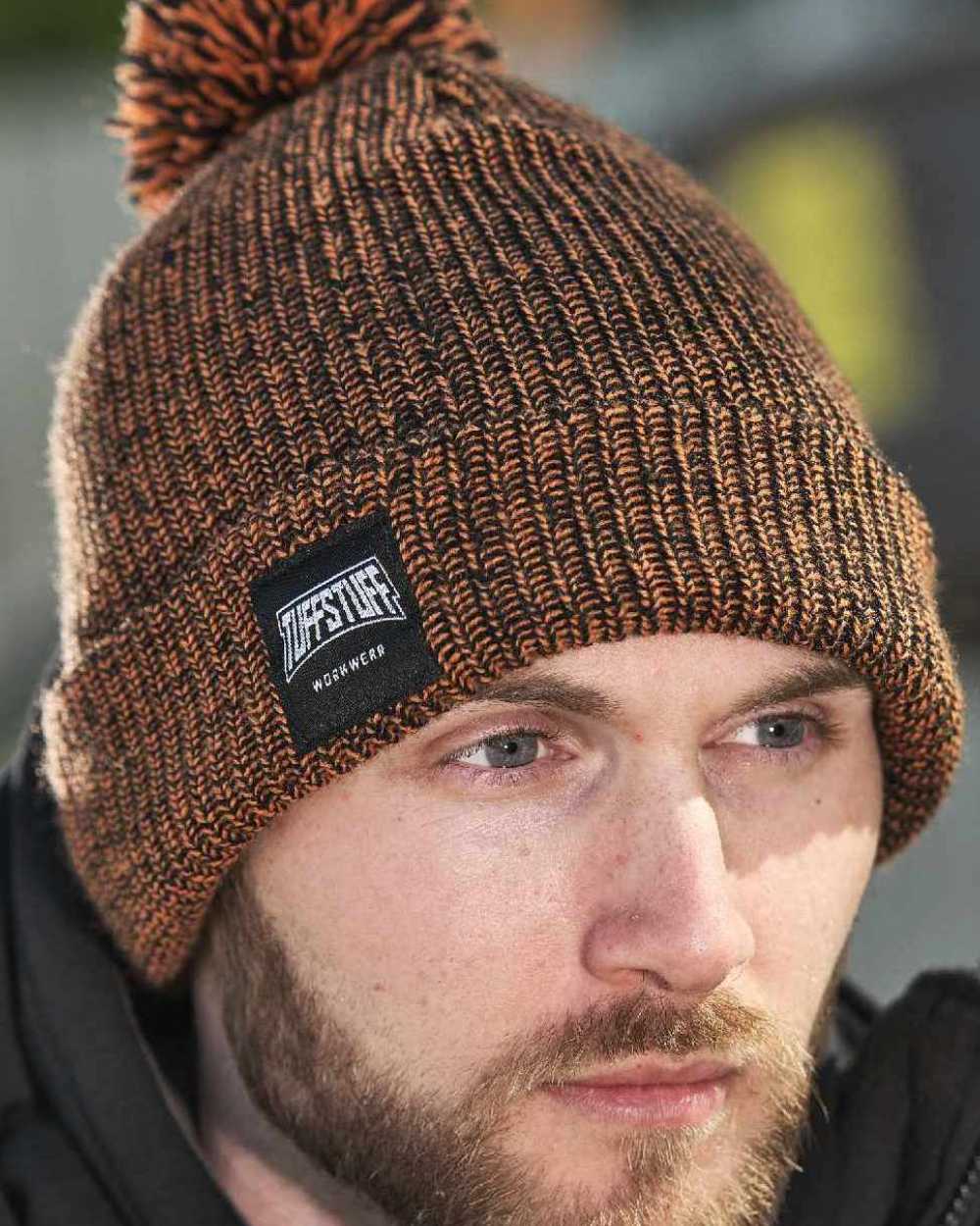 Orange Coloured TuffStuff Elite Bobble Hat On A Farm House Background