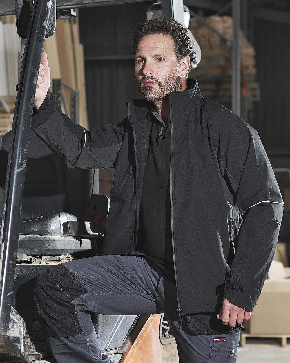 Black Coloured TuffStuff Stanton Waterproof Softshell Jacket On A Warehouse Background 