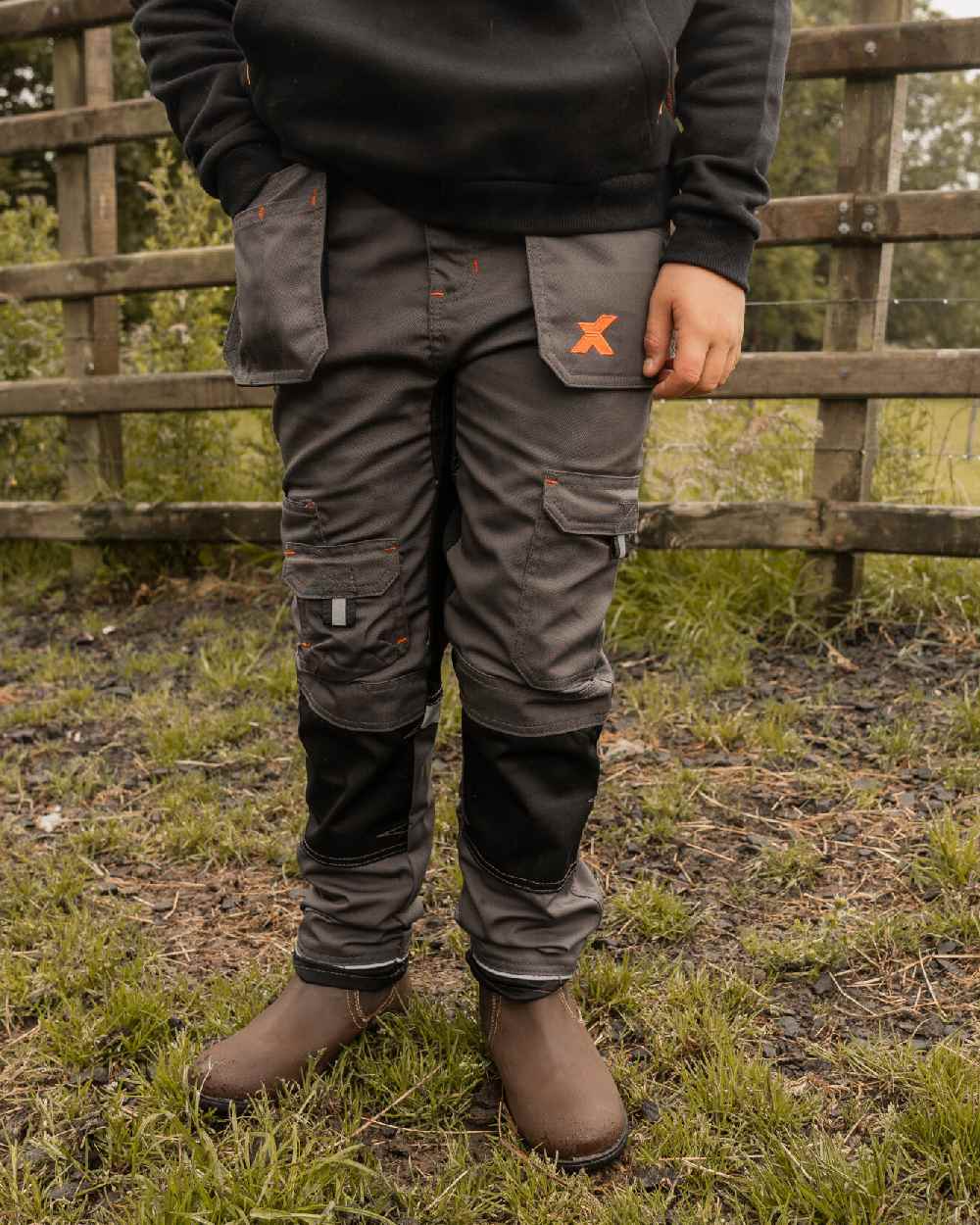 Grey Coloured Xpert Children Pro Stretch Work Trousers on Outdoor Background
