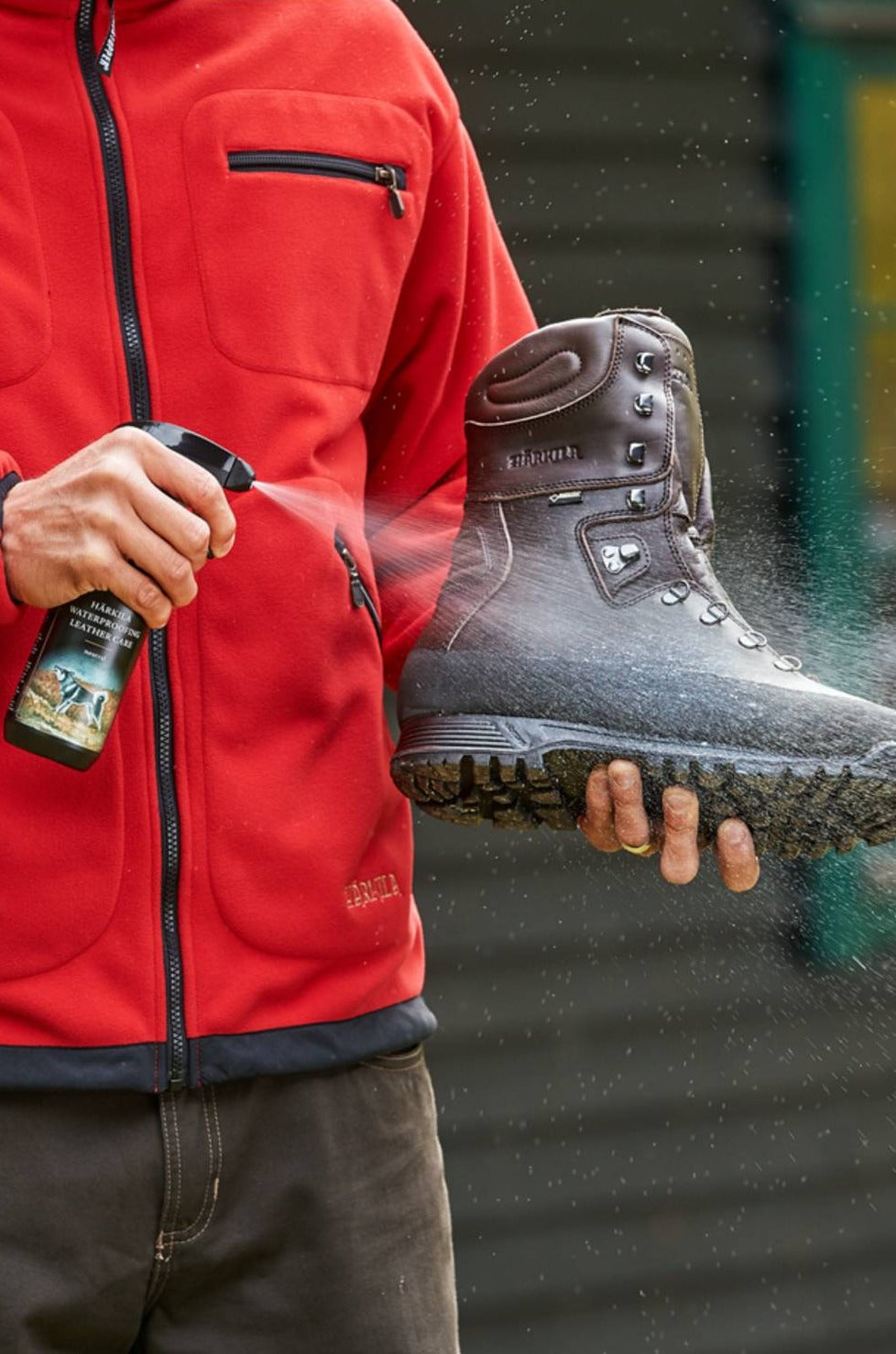 Harkila Waterproofing Leather Care Neutral showing someone squirting the product onto a pair of boots