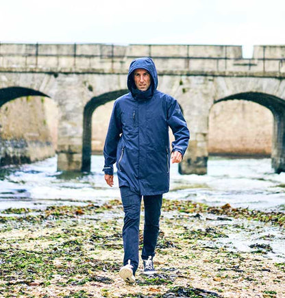 Musto Sardinia Long Rain Jacket walking by a river 