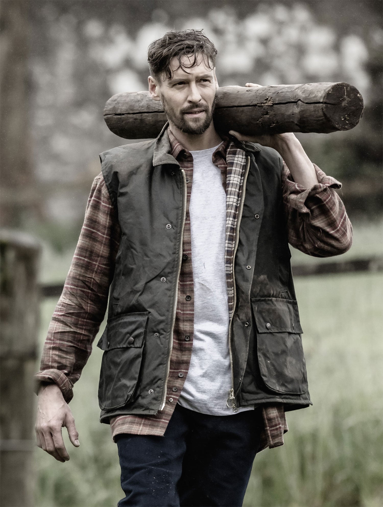 carrying a log Hoggs Waxed Waistcoat, a traditionally styled country wax garment from Hoggs