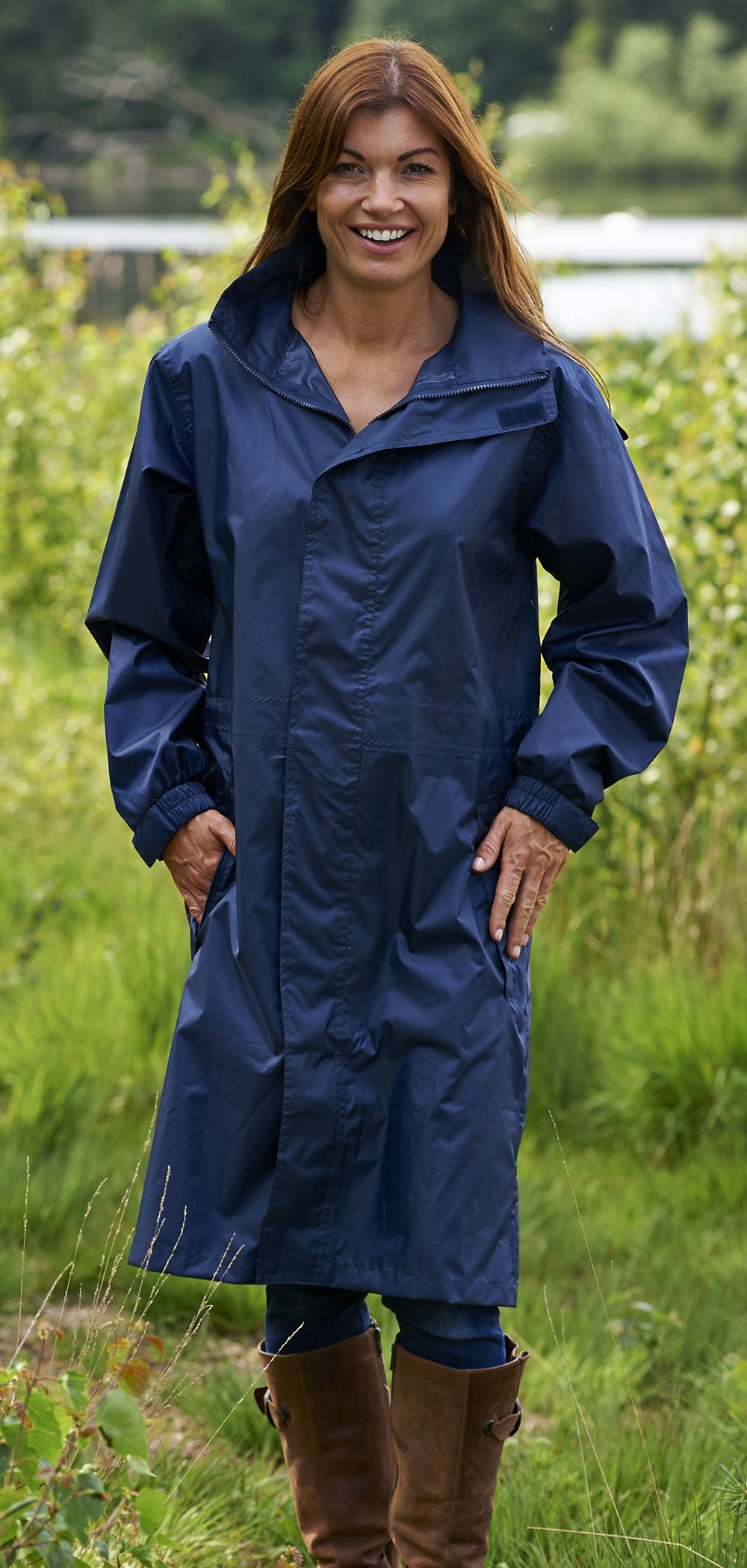 Woman wearing navy coloured waterproof Champion Storm Long Rain Coat.